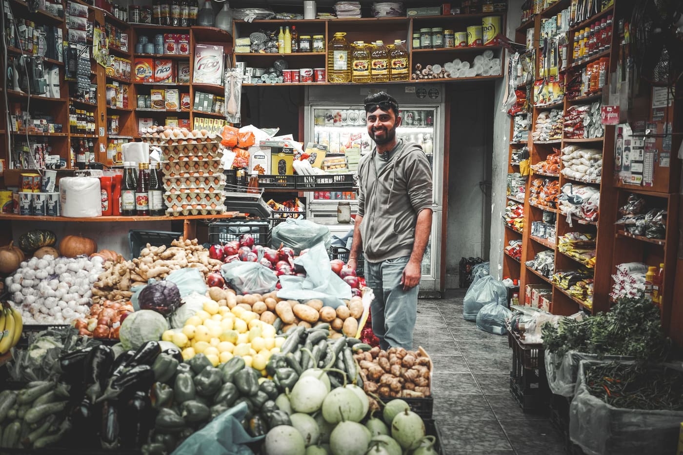 Interno del punto vendita BP Commerce con scaffali di alimentari, casalinghi e frutta e verdura fresca